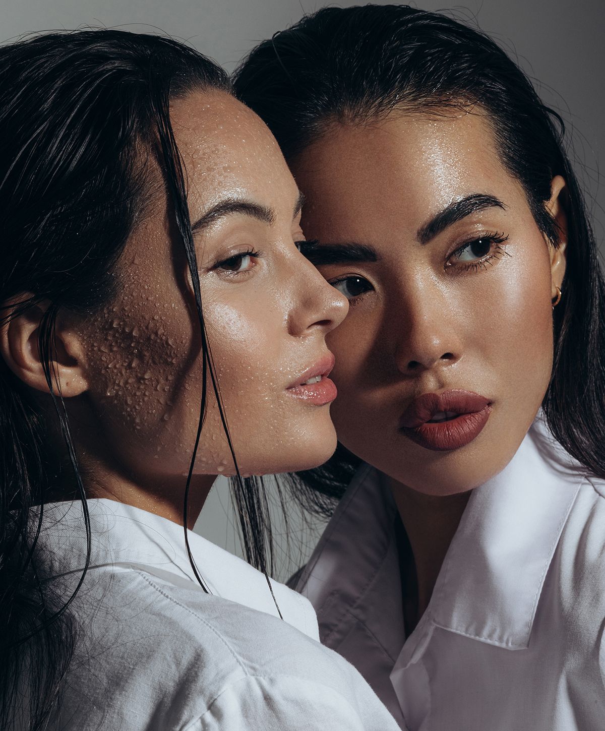 Two women with wet hair and glowing skin.