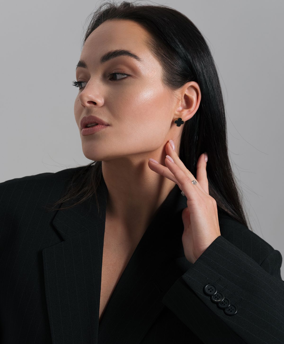 Model showcasing jewelry in stylish black attire.