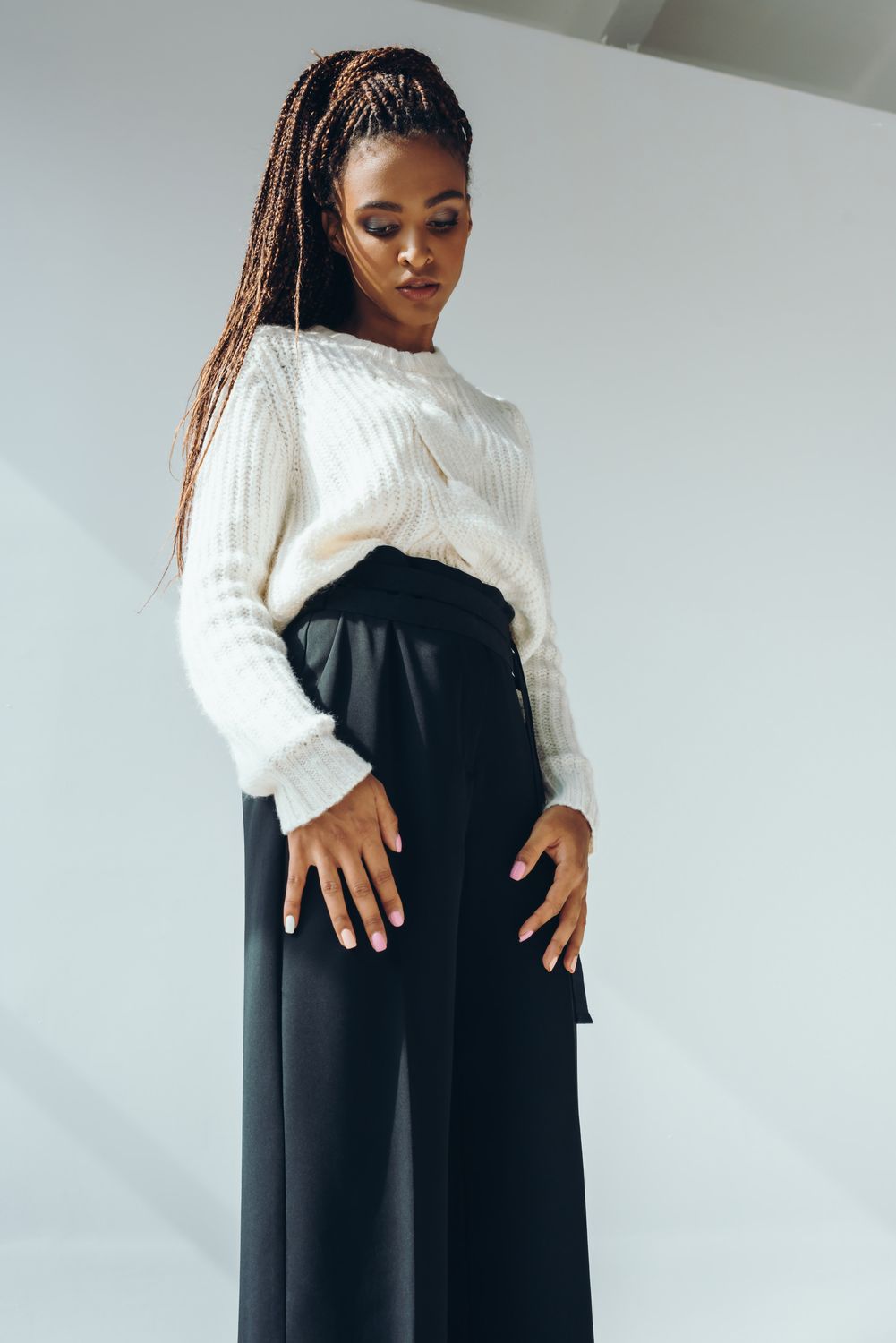 Model with hand on face, showcasing jewelry.
